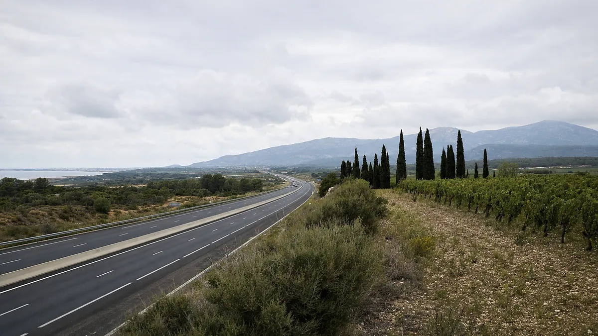 Une autoroute du littoral languedocien filant vers le sud, vignes et garrigue de part et d’autre.
