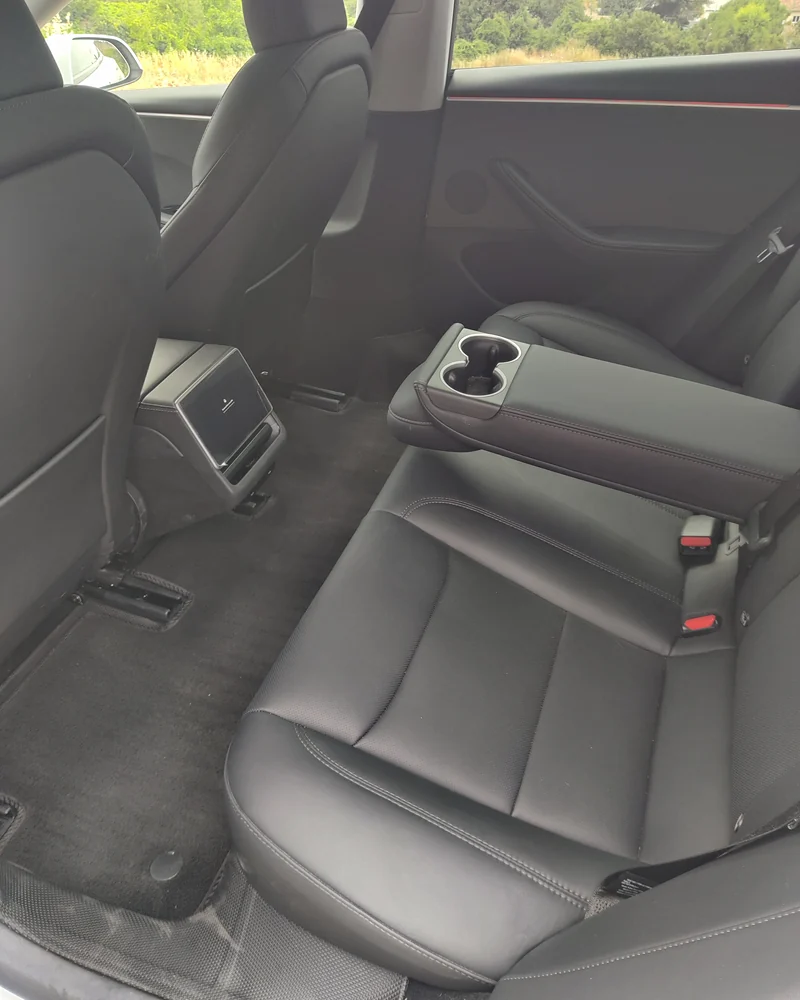 Banquette arrière en cuir de la Tesla Model 3 d’Aude VTC, accoudoir central rabattu.