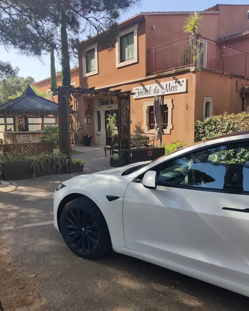 La Tesla Model 3 blanche d’Aude VTC devant un hôtel à Vinassan, sur l’axe Narbonne–Perpignan.